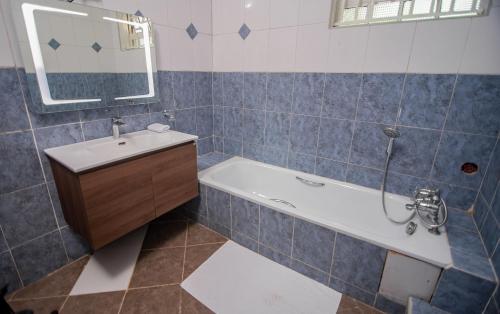 a bathroom with a tub and a sink and a mirror at Lovely Garden Guest Home in Kisumu