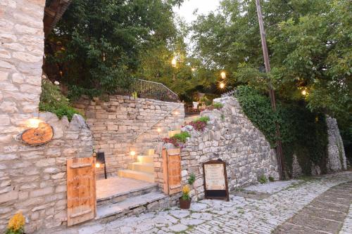 a stone wall with a set of stairs and a stone stairway at Vikos Hotel in Monodendri