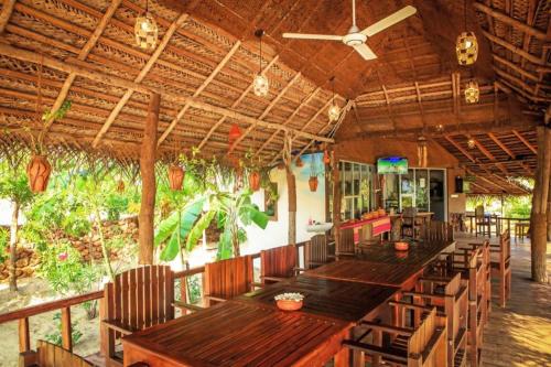 阿魯岡灣的住宿－Whisky Point Surf Cabana，餐厅设有长木桌子和椅子