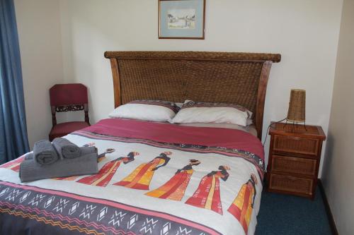 uma cama com colcha e chinelos em Ocean View On Disa em Malkopvlei