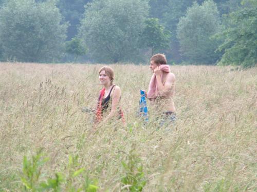two people walking through a field of tall grass at Het Zwaantje in Londerzeel