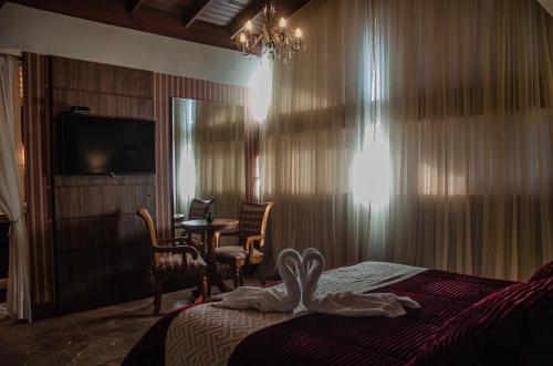 a hotel room with a bed with a swan towel on it at Pousada Lanai Gramado in Gramado