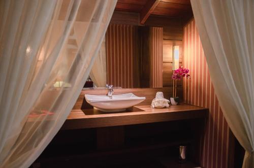 a bathroom with a sink and a mirror at Pousada Lanai Gramado in Gramado