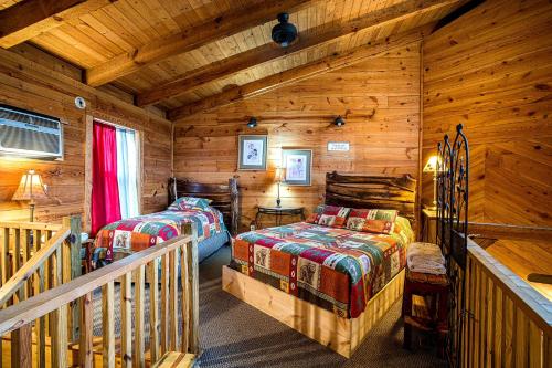a bedroom with two beds in a log cabin at The TreeHouse - Rocking Chair Deck with Hot Tub below, Walking Distance to Downtown Helen, Sleeps 5 in Helen