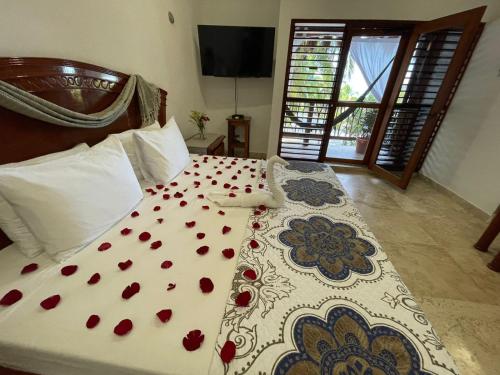 a bedroom with a bed with red flowers on it at Casa Pirata in Holbox Island