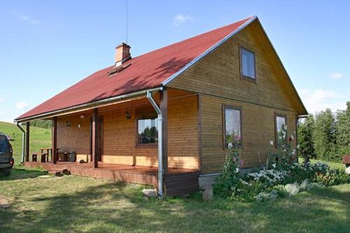 una pequeña casa de madera con techo rojo en Brīvdienu māja Vīteri, en Biksinīki