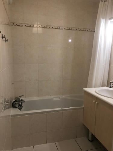 y baño con bañera y lavamanos. en ARCACHON appartement T2 51M2 et parking privatif en sous sol en Arcachón