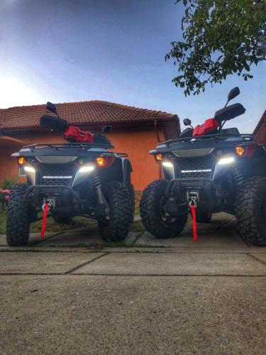 two atvs parked in front of a house at Casa Andra in Baia de Fier