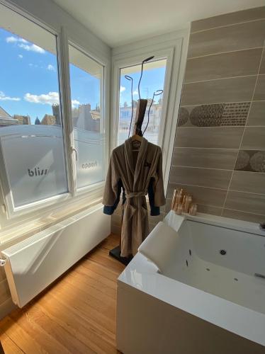 une salle de bain avec une baignoire et une fenêtre dans l'établissement Bliss’appart boulogne/mer logement avec balnéothérapie, à Boulogne-sur-Mer