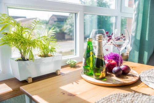 a table with two bottles of wine and plants on it at Sweet XS in Boryspilʼ