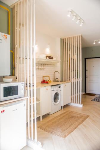 a kitchen with white cabinets and a washer and dryer at Sweet XS in Boryspilʼ