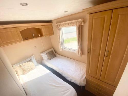 A bed or beds in a room at Luxury 2 Bedroom 2 bathroom Caravan-small sofa 1 pers