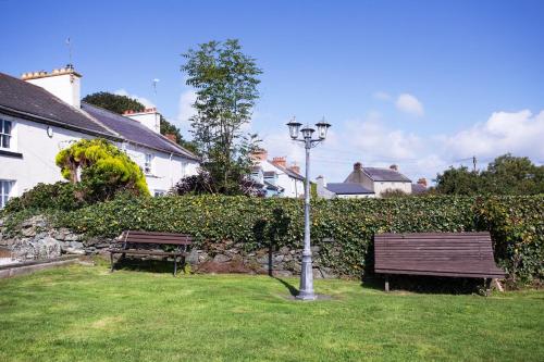 a wooden bench sitting on top of a lush green field at Burford Lodge Guest House in Ardglass