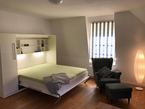 ein Schlafzimmer mit einem Bett, einem Stuhl und einem Fenster in der Unterkunft Villa Friedericia - Whg4 in Wyk auf Föhr