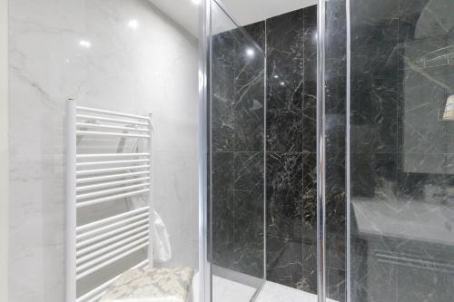 une salle de bain avec une douche avec une porte vitrée dans l'établissement Cosy YourHostHelper, à Cannes