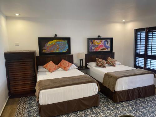 two beds in a hotel room with two at Hotel Raices de Mar in Mazatlán