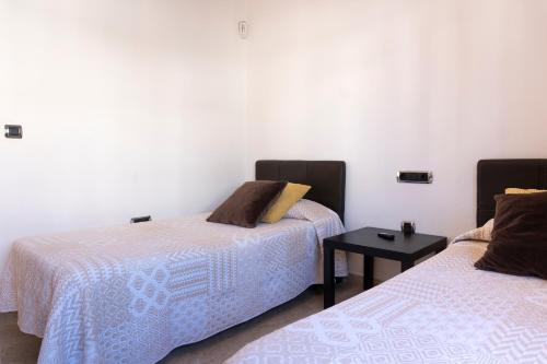 a room with two beds and a side table at Villa Eris in Puerto del Carmen