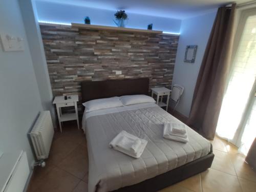 1 dormitorio con cama y pared de ladrillo en B&B Il Tramonto en Pastrengo