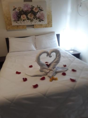 a pair of hands forming a heart on a bed at Pousada Danitato e lavanderia in Bom Jardim