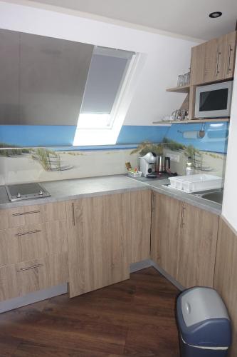 a kitchen with wooden cabinets and a sink and a window at Gasthof & Restaurant "Am Kreuz" in Essen