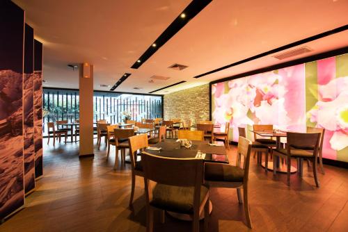 a restaurant with tables and chairs and a wall with flowers at Arawi Miraflores Prime in Lima