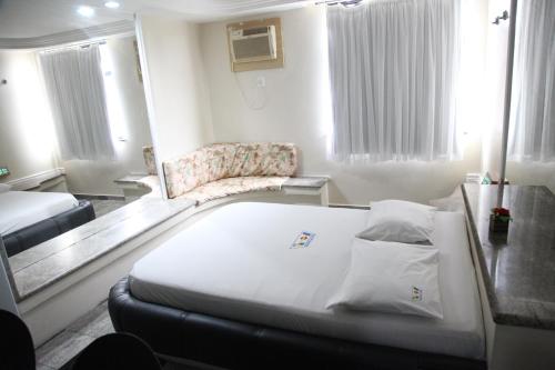 um quarto com uma cama e uma cadeira em Piramide Stella Maris Adults Only em Salvador