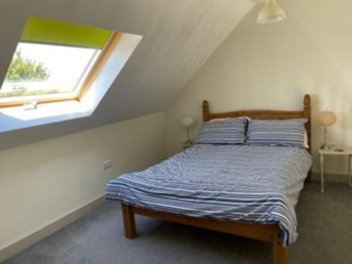 Bett in einem Zimmer mit Fenster in der Unterkunft Bike Shed - Beautiful 1-Bed Cottage in Shorwell in Shorwell