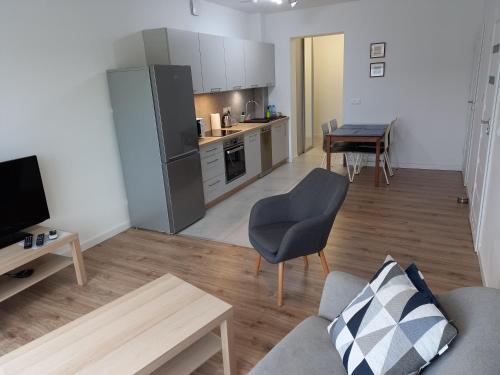 ein Wohnzimmer mit einem Sofa und einem Tisch sowie eine Küche in der Unterkunft Leszno City Center Apartments in Leszno