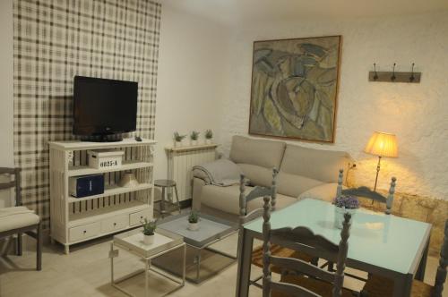 sala de estar con sofá y TV en Villa Caramel, en Villalba de la Sierra