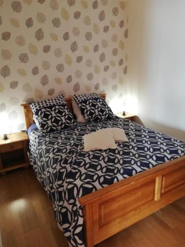 une chambre avec un lit avec une couette noire et blanche dans l'établissement f2 gerardmer, à Gérardmer