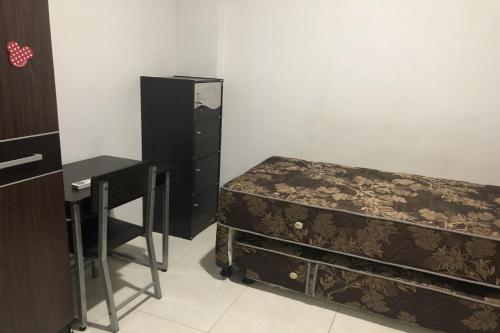 a bedroom with a bed and a desk and a table at Charisma Residence Syariah in Surabaya