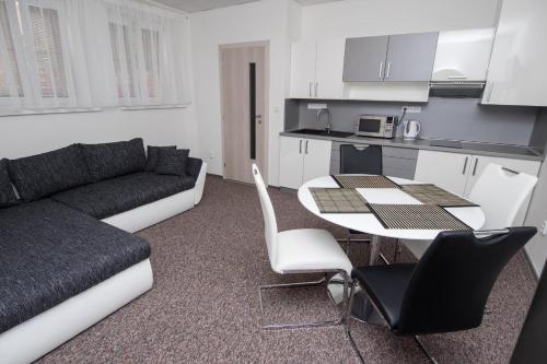 - un salon avec un canapé et une table avec des chaises dans l'établissement Apartmany Anna Nicole, à Karlovy Vary