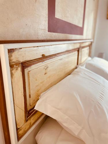 a wooden headboard of a bed with a white pillow at Il giardino di Iole Via Giovanni Amendola n36 in Sassari