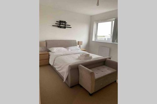 a bedroom with a bed with a chair and a window at Luxury 1 Bedroom Apartment with Netflix & Parking in Borehamwood