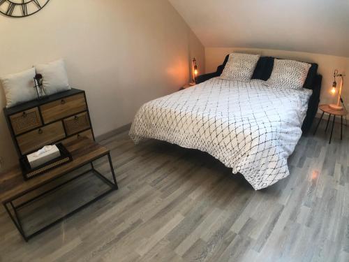 a bedroom with a bed and a wooden floor at La Maison du Moulin à Vent in La ForestiÃ¨re