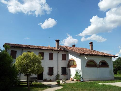 duży biały dom z drzewem przed nim w obiekcie BB Parco del Mincio w mieście Virgilio