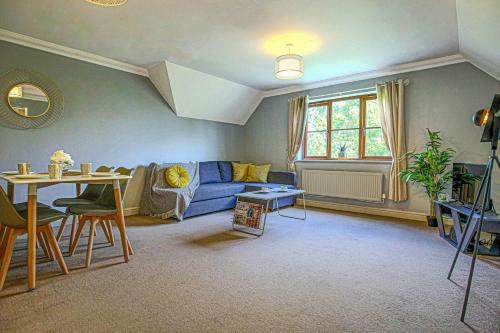a living room with a blue couch and a table at Executive Monkston Apartment by PAY AS U STAY in Milton Keynes