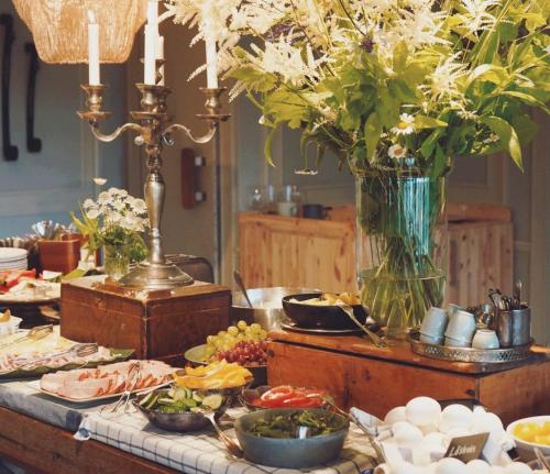a buffet with plates of food and a vase of flowers at Hotell Åre Fjällsätra in Undersåker