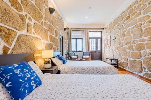 a room with two beds and a stone wall at Riverside City Centre Apartments in Porto