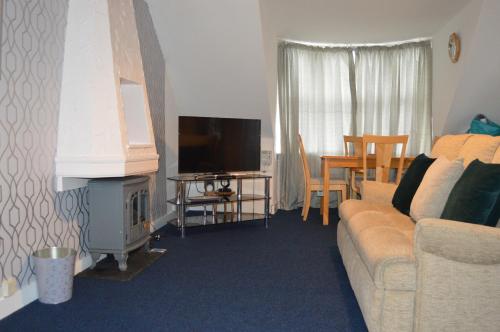 a living room with a couch and a television at Holiday Apartment Dunfermline in Dunfermline