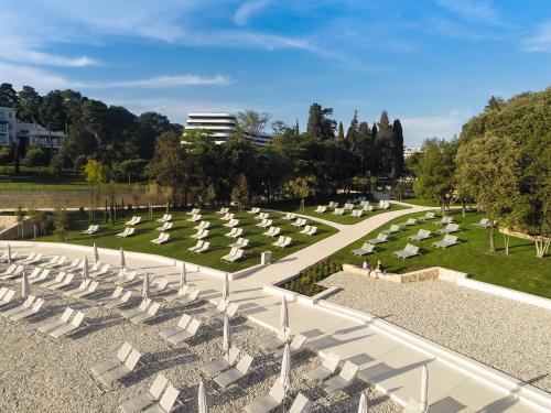 a park with white chairs and a cemetery at Lone Hotel by Maistra Collection in Rovinj
