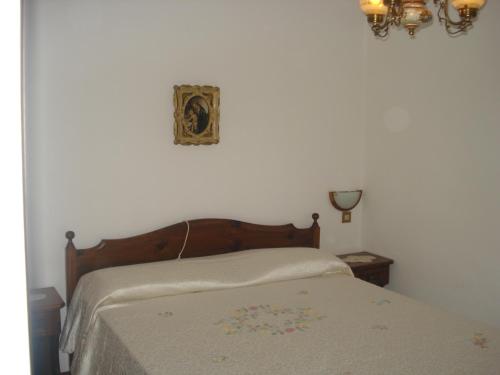 a bed in a bedroom with a white wall at Albergo Larese in Auronzo di Cadore
