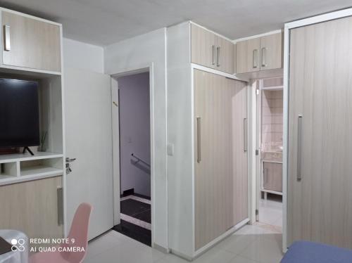 um quarto com paredes brancas e uma televisão e uma porta em Eilat. אילת Pousada Bacacheri em Curitiba