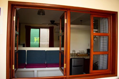 a living room with a blue couch and a window at Poza Clara Sanctuary in Bacalar