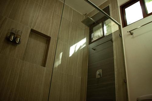 a shower with a glass door in a bathroom at Poza Clara Sanctuary in Bacalar