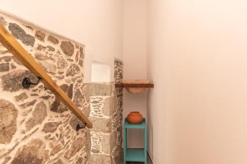 een trap met een stenen muur en een tafel met een vaas bij El blanquizal in San Nicolás