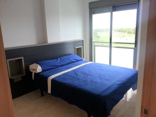 オリーバにあるOliva Novaのベッドルーム(青いベッド1台、大きな窓付)