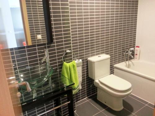 オリーバにあるOliva Novaの黒いタイルのバスルーム(白いトイレ付)