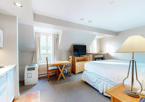 a bedroom with a bed and a desk and a television at Whistler Peak Lodge by TS in Whistler