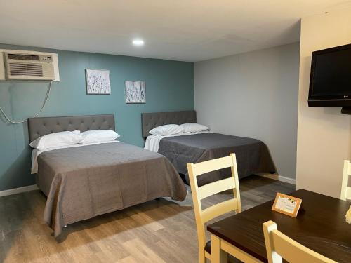 Cette chambre comprend deux lits, une table et une table. dans l'établissement Superlodge, à Dover